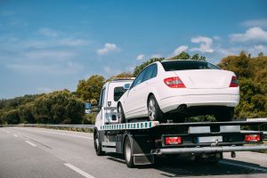 Car Service Transportation Concept. Tow Truck Transporting Car Or Help On Road Transports Wrecker Broken Car. Auto Towing, Tow Truck For Transportation Faults And Emergency Cars . Tow Truck Moving In Motorway Freeway Highway