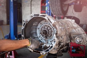 Auto mechanic working on car automatic transmission in auto repair shop. Welding for strengthen anchor pin of plate and torque  Converter for Automatic Transmission